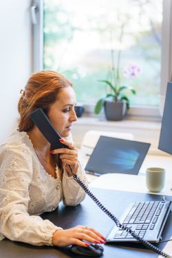 Sachbearbeiterin im Kundenservice telefoniert am Arbeitsplatz